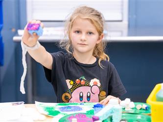 student displaying craft