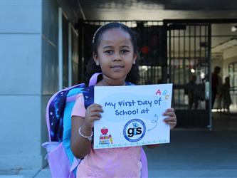 student holding first day of school sign