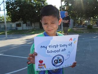 student holding first day of school sign