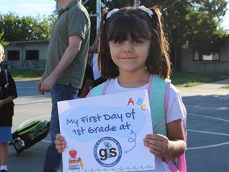 student holding first day of school sign