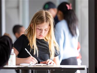 student writing into book 