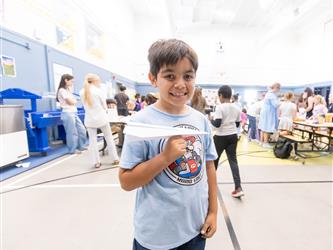 child showing paper air plane