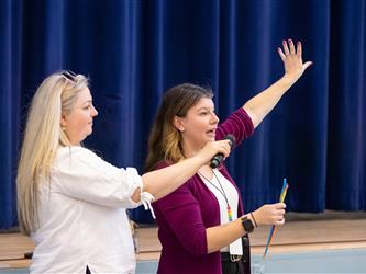 two women raising hands