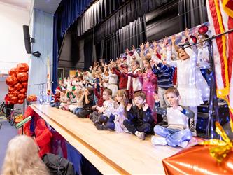 students excitedly performing for event