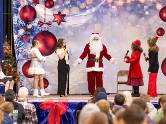 students performing on stage with santa