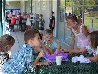 principal and superintendent speaking with student playing