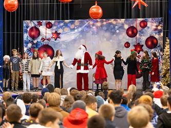 students performing on stage with santa