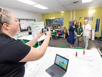 teacher laughing at desk 