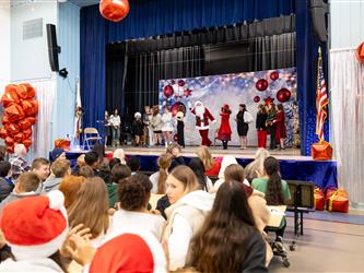 students performing on stage with santa