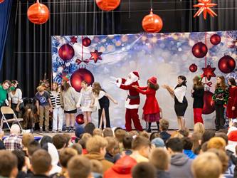 students performing on stage with santa