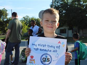 student holding first day of school sign