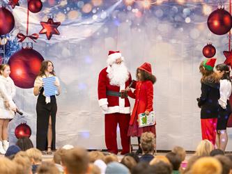 students performing on stage with santa