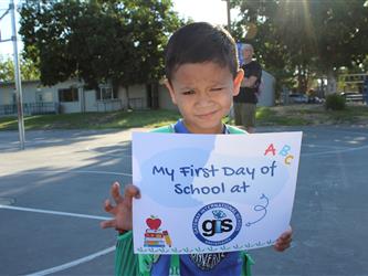 student holding first day of school sign