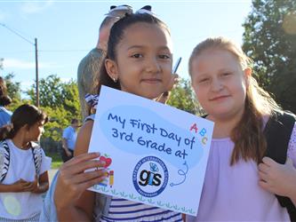 student holding first day of school sign