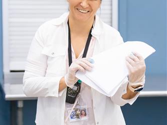 staff holding stack of papers 