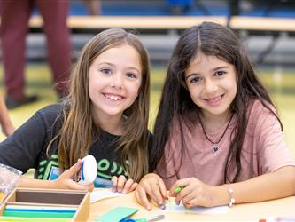 two students posing at table 