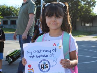 student holding first day of school sign