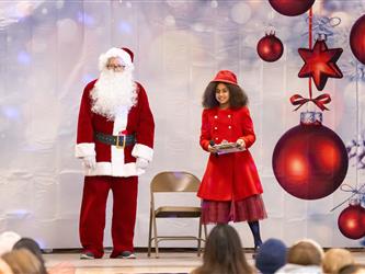 students performing on stage with santa