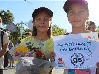 student holding first day of school sign