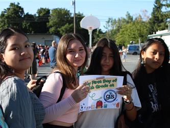 students holding first day of school sign