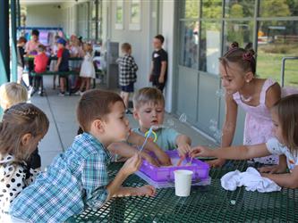 principal and superintendent speaking with student playing