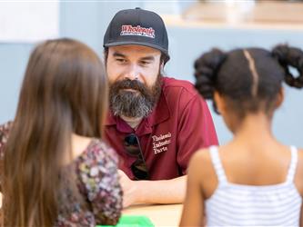 staff engaged with students at table 