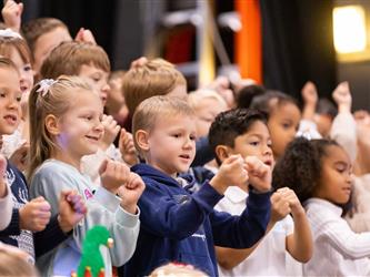 students excitedly performing for event