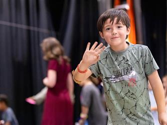 child waving to camera 