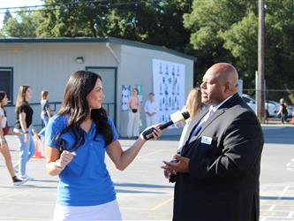 news team speaking with superintendent