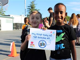 student holding first day of school sign