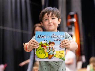 child posing with award 